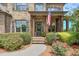 Charming front door with an American flag, stone stairs and beautiful landscaping in this stunning, inviting home at 7045 Parrish Way, Cumming, GA 30040