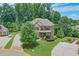 Landscaped front yard of this beautiful two-story home showcasing a lush lawn, decorative shrubs, and trees at 7045 Parrish Way, Cumming, GA 30040