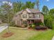 A beautiful house showcasing a manicured front yard, colorful landscaping, and a mix of brick and stone accents at 7045 Parrish Way, Cumming, GA 30040
