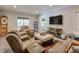 Spacious living room with comfortable sofas, a large TV, and a view of the outdoor scenery at 7045 Parrish Way, Cumming, GA 30040