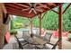 The covered patio boasts an outdoor dining area and a ceiling fan, overlooking the sparkling pool and landscaped yard at 7045 Parrish Way, Cumming, GA 30040