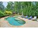 Lush backyard showcasing a kidney-shaped pool surrounded by lounge chairs and mature trees at 7045 Parrish Way, Cumming, GA 30040