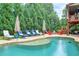 The sparkling in-ground pool is surrounded by comfortable lounge chairs, umbrellas, and lush landscaping at 7045 Parrish Way, Cumming, GA 30040