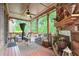 Inviting outdoor porch features a stone fireplace, ample seating, and views of the trees at 7045 Parrish Way, Cumming, GA 30040