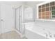Bright bathroom with a separate shower and a soaking tub next to a window at 735 Scenic Creek Dr, Lawrenceville, GA 30046