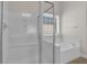 Bright bathroom with a glass-enclosed shower and a soaking tub next to a window at 735 Scenic Creek Dr, Lawrenceville, GA 30046