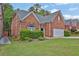 View of the side of a red brick home with lush green lawn and tidy landscaping at 735 Scenic Creek Dr, Lawrenceville, GA 30046