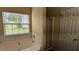 Comfortable bathroom featuring a jetted tub, and a separate shower at 7518 Edenberry Way, Lithonia, GA 30058