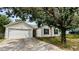 Inviting single-story home featuring an attached two-car garage and mature landscaping at 7518 Edenberry Way, Lithonia, GA 30058