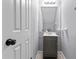 Compact half bathroom with a gray vanity, stylish mirror, and neutral decor at 1106 Rock Creek Ln, Norcross, GA 30093