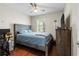 Cozy bedroom featuring hardwood floors, a ceiling fan and a rustic wooden bed frame at 1106 Rock Creek Ln, Norcross, GA 30093