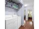 Laundry area with white washer and dryer, storage shelves and hardwood floors at 1106 Rock Creek Ln, Norcross, GA 30093