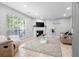 Well-lit living room featuring a fireplace, a large window, and comfortable neutral furniture at 1106 Rock Creek Ln, Norcross, GA 30093