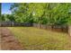 Grassy backyard enclosed by a wooden fence with mature trees and shrubs at 1596 Foote Ne St, Atlanta, GA 30307