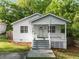Quaint home featuring a covered front porch, white siding, and neat landscaping for a cozy curb appeal at 1596 Foote Ne St, Atlanta, GA 30307