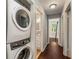 Hallway with stackable washer and dryer, leading to bedrooms and bathroom with wood floors throughout at 1596 Foote Ne St, Atlanta, GA 30307