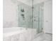Bright bathroom features a luxurious soaking tub and a glass-enclosed shower with marble tiling at 2119 Dee Dee Muse Nw Ln, Atlanta, GA 30318