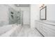 Luxurious bathroom with a soaking tub, glass-enclosed shower, marble flooring, and white cabinets at 2119 Dee Dee Muse Nw Ln, Atlanta, GA 30318