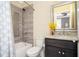 Bright bathroom featuring a granite-topped vanity, updated fixtures and tiled shower at 2119 Dee Dee Muse Nw Ln, Atlanta, GA 30318