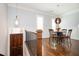 Elegant dining area with hardwood floors and modern lighting next to wooden door and stairway at 2119 Dee Dee Muse Nw Ln, Atlanta, GA 30318