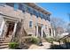 Beautiful brick townhome featuring multiple windows, covered entrances, and manicured landscaping at 2119 Dee Dee Muse Nw Ln, Atlanta, GA 30318