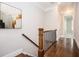 Inviting hallway featuring hardwood floors, modern art, and a staircase with a wood railing at 2119 Dee Dee Muse Nw Ln, Atlanta, GA 30318