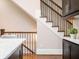 Elegant staircase with dark wood railing and iron spindles, complemented by kitchen elements at 2119 Dee Dee Muse Nw Ln, Atlanta, GA 30318