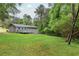 Beautiful backyard featuring lush green grass, mature trees, a wood deck, and a chain link fence at 4855 Brownsville Rd, Powder Springs, GA 30127