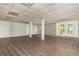 Spacious basement featuring modern vinyl plank flooring, white support beams, and multiple doors to other rooms at 4855 Brownsville Rd, Powder Springs, GA 30127