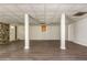 A spacious finished basement features wood floors, stone accent wall, windows, support columns, and a door at 4855 Brownsville Rd, Powder Springs, GA 30127