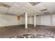 A spacious finished basement features wood floors, stone accent wall, windows, support columns, and access doors at 4855 Brownsville Rd, Powder Springs, GA 30127