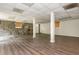 A spacious finished basement features wood floors, stone accent wall, windows, and support columns at 4855 Brownsville Rd, Powder Springs, GA 30127