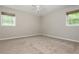 Spacious bedroom with neutral walls, carpet floors, and windows overlooking wooded scenery at 4855 Brownsville Rd, Powder Springs, GA 30127