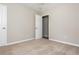 A bedroom features neutral walls, carpet, and an open closet with a white door at 4855 Brownsville Rd, Powder Springs, GA 30127