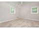 A bedroom features neutral walls, carpet, ceiling fan, and two windows for natural light at 4855 Brownsville Rd, Powder Springs, GA 30127
