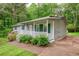 Charming single-story home with a covered front porch, manicured landscaping and a tree-lined backdrop at 4855 Brownsville Rd, Powder Springs, GA 30127