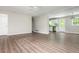 A dining/living area features hardwood flooring with an adjacent kitchen featuring white cabinets and stainless steel appliances at 4855 Brownsville Rd, Powder Springs, GA 30127