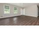 A spacious living room features hardwood flooring and two windows with shade coverings at 4855 Brownsville Rd, Powder Springs, GA 30127