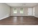 A spacious living room features hardwood flooring, a ceiling fan, and two windows with shade coverings at 4855 Brownsville Rd, Powder Springs, GA 30127