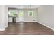 A dining/living area features hardwood flooring with an adjacent kitchen featuring white cabinets and stainless steel appliances at 4855 Brownsville Rd, Powder Springs, GA 30127