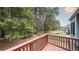 A spacious wooden back deck overlooks a lush, wooded yard with a fence line at 570 Highcrest Dr, Acworth, GA 30101