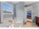 Bathroom featuring a soaking tub with tile surround and a window with a view at 129 Lakepointe Ct, Stockbridge, GA 30281