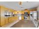 Open-concept kitchen with wood cabinets, stainless steel appliances, and view into the living room at 129 Lakepointe Ct, Stockbridge, GA 30281