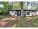 Backyard featuring a painted brick house, black trim, small wood deck, and mature trees at 2094 Shamrock Dr, Decatur, GA 30032