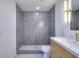 Modern bathroom featuring a walk-in shower with gray herringbone tile and a light wood vanity at 2094 Shamrock Dr, Decatur, GA 30032