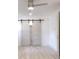 Bedroom with vinyl floors, neutral paint, ceiling fan, and a white barn door at 2094 Shamrock Dr, Decatur, GA 30032