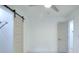 Bedroom with vinyl floors, neutral paint, ceiling fan, and a white barn door at 2094 Shamrock Dr, Decatur, GA 30032