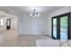 Dining room with modern chandelier, access to deck, and light wood floors at 2094 Shamrock Dr, Decatur, GA 30032