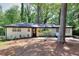 Charming white brick home with black trim, a new roof, manicured landscaping, and mature trees at 2094 Shamrock Dr, Decatur, GA 30032