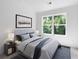 Bedroom featuring a comfortable bed, stylish decor, and a large window with a backyard view at 308 Chardonnay Way, Woodstock, GA 30188